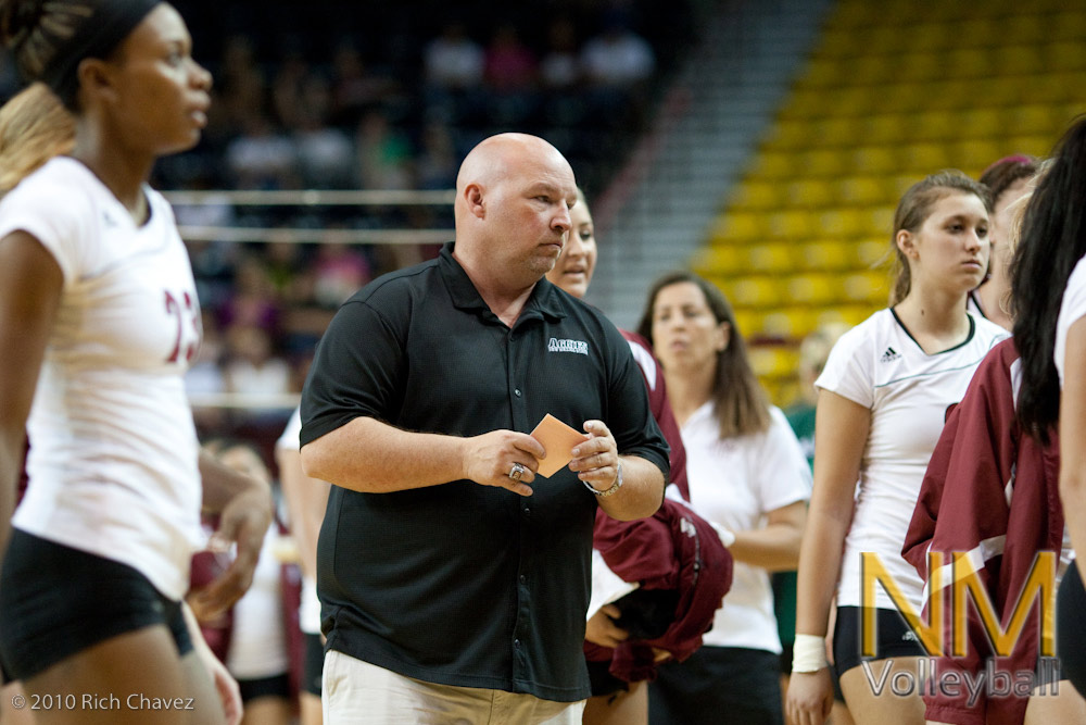 NMSU head coach Mike Jordan prepares to talk to his team before the second set